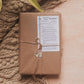 Gift wrapped in brown paper with string, placed on a textured surface.